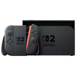 La console Nintendo Switch 2 insérée dans sa station d'accueil noire (dock TV) à côté du support pour manettes Joy-Con